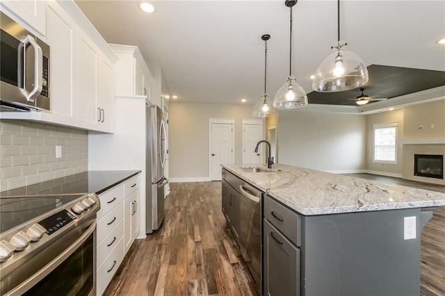 15904 E Cogan Ln, Independence, MO 64050 - kitchen with stainless steel appliances, recessed lighting, a center island with sink, a ceiling fan, and dark wood-type flooring