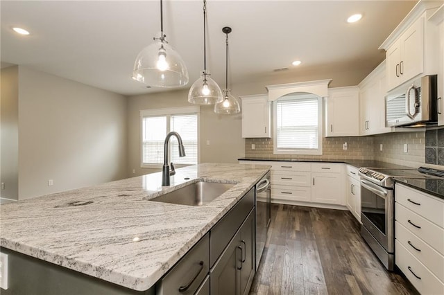 15904 E Cogan Ln, Independence, MO 64050 - kitchen with stainless steel appliances, a center island with sink, healthy amount of natural light, dark wood-style floors, and recessed lighting