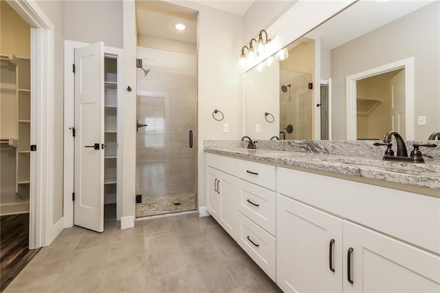 15904 E Cogan Ln, Independence, MO 64050 - bathroom with a spacious closet, double vanity, a shower stall, tile patterned floors, and recessed lighting