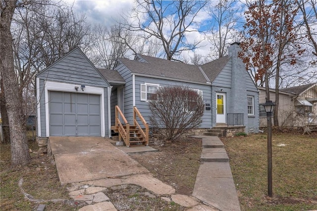 904 E 84th St, Kansas City, MO 64131 - view of front of house featuring roof with shingles, a chimney, driveway, an attached garage, and a front yard