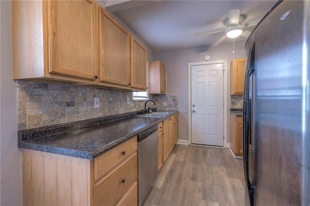 904 E 84th St, Kansas City, MO 64131 - kitchen with appliances with stainless steel finishes, light wood finished floors, tasteful backsplash, dark countertops, and ceiling fan