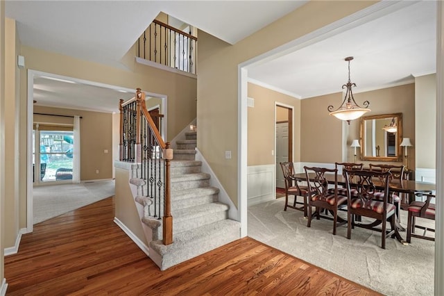508 Ambersham Dr, Lees Summit, MO 64081 - carpeted dining area featuring wood finished floors, stairway, and ornamental molding