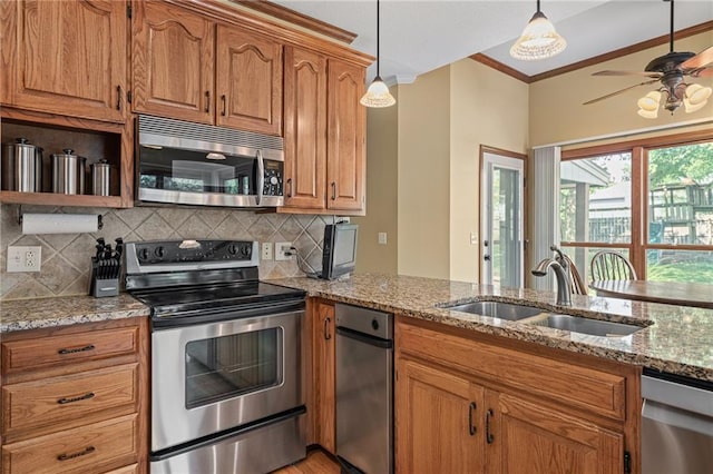 508 Ambersham Dr, Lees Summit, MO 64081 - kitchen with crown molding, appliances with stainless steel finishes, backsplash, light stone counters, and brown cabinetry