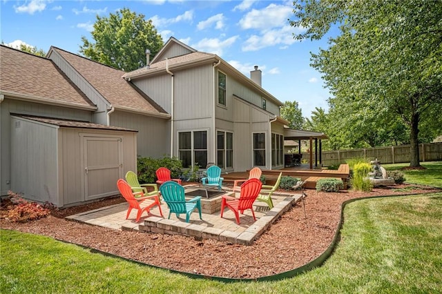 508 Ambersham Dr, Lees Summit, MO 64081 - rear view of property with a fire pit, a storage unit, a chimney, a patio area, and a shingled roof