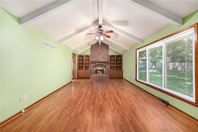 6319 Acuff St, Shawnee, KS 66216 - unfurnished living room featuring a textured ceiling, wood finished floors, a ceiling fan, and a fireplace