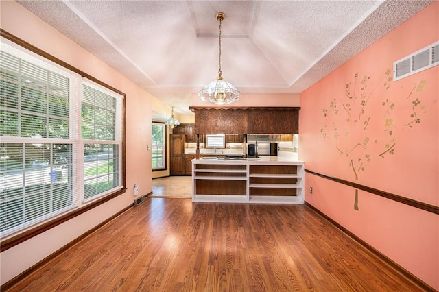 6319 Acuff St, Shawnee, KS 66216 - kitchen with a chandelier, wood finished floors, a peninsula, light countertops, and a textured ceiling