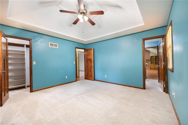 6319 Acuff St, Shawnee, KS 66216 - unfurnished bedroom featuring a raised ceiling, carpet, a spacious closet, a textured ceiling, and a ceiling fan