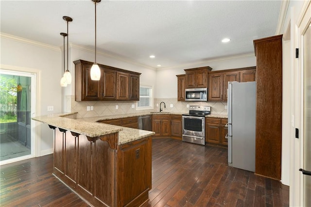 28617 W 162nd Ter, Gardner, KS 66030 - kitchen with a peninsula, stainless steel appliances, dark wood finished floors, light stone counters, and pendant lighting