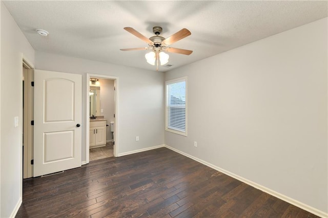 28617 W 162nd Ter, Gardner, KS 66030 - unfurnished bedroom with dark wood-type flooring, connected bathroom, a ceiling fan, and a textured ceiling