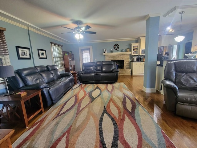 19823 74th St, Mclouth, KS 66054 - living area with a ceiling fan, dark wood-type flooring, ornamental molding, and a stone fireplace