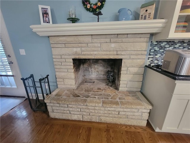 19823 74th St, Mclouth, KS 66054 - detailed view of wood finished floors, a fireplace, and backsplash