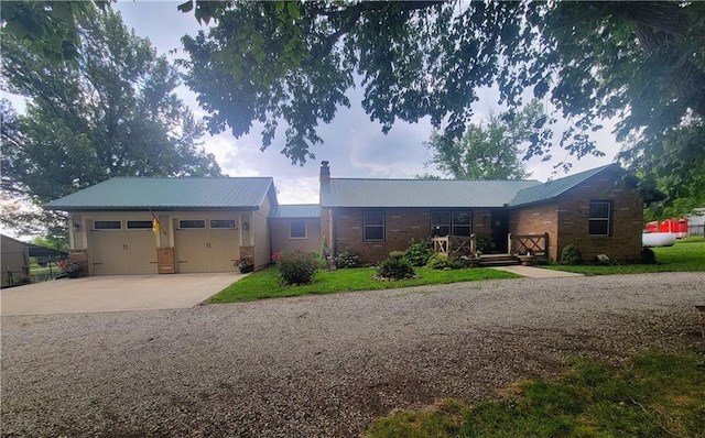 19823 74th St, Mclouth, KS 66054 - ranch-style home with a metal roof, concrete driveway, brick siding, and a garage