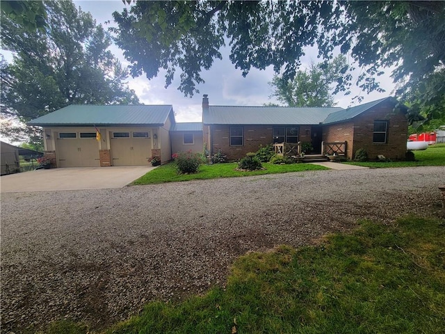 19823 74th St, Mclouth, KS 66054 - ranch-style house featuring a metal roof, driveway, a garage, and brick siding