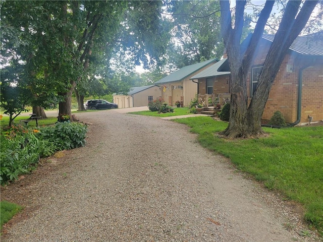 19823 74th St, Mclouth, KS 66054 - view of front of house with driveway, brick siding, and a front lawn