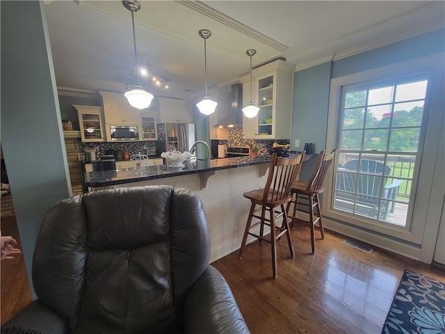 19823 74th St, Mclouth, KS 66054 - kitchen with ornamental molding, wall chimney range hood, glass insert cabinets, and decorative backsplash