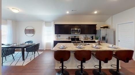 550 W Fountain St, Gardner, KS 66030 - kitchen with a breakfast bar, stainless steel appliances, a kitchen island with sink, wood finished floors, and recessed lighting