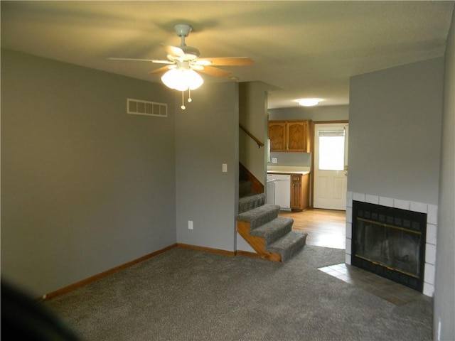 730 SE 10th St, Lees Summit, MO 64081 - unfurnished living room with a tile fireplace, stairway, light colored carpet, and ceiling fan