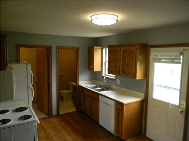 730 SE 10th St, Lees Summit, MO 64081 - kitchen with white appliances, wood finished floors, brown cabinets, and light countertops