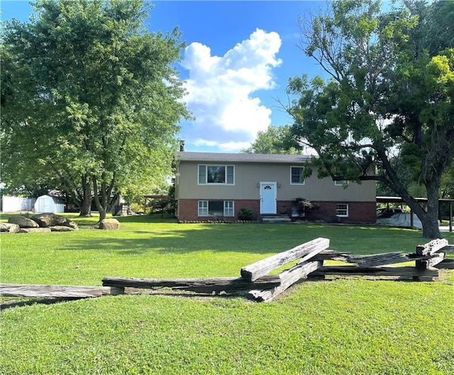 177 1150th St, Humboldt, KS 66748 - rear view of property with brick siding, a storage shed, and a lawn