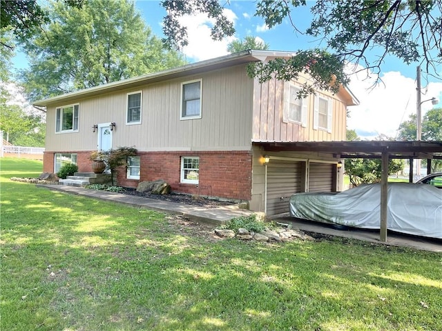 177 1150th St, Humboldt, KS 66748 - view of home's exterior featuring brick siding, a garage, and a yard