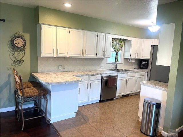 177 1150th St, Humboldt, KS 66748 - kitchen featuring a peninsula, light countertops, decorative backsplash, white cabinetry, and recessed lighting