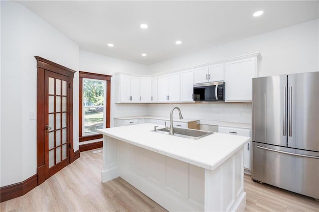 308 W Pine St, Cherokee, KS 66724 - kitchen featuring stainless steel appliances, light wood finished floors, tasteful backsplash, white cabinets, and recessed lighting