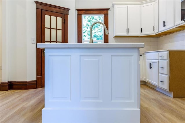 308 W Pine St, Cherokee, KS 66724 - kitchen with light wood-type flooring, white cabinetry, and light countertops