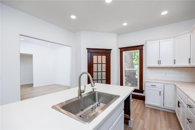 308 W Pine St, Cherokee, KS 66724 - kitchen with light wood-style flooring, light countertops, recessed lighting, white cabinets, and decorative backsplash