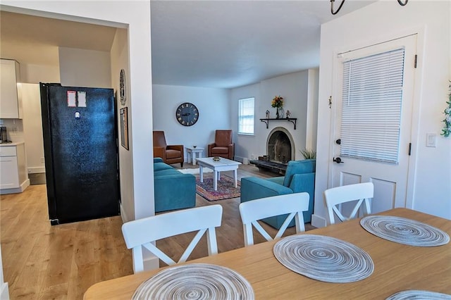 2439 Jasu Dr, Lawrence, KS 66046 - dining space with light wood finished floors and a fireplace with raised hearth