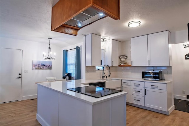 2439 Jasu Dr, Lawrence, KS 66046 - kitchen featuring open shelves, light wood-type flooring, a chandelier, white cabinets, and a textured ceiling