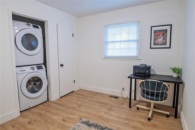 2439 Jasu Dr, Lawrence, KS 66046 - laundry room featuring stacked washer / drying machine and light wood finished floors
