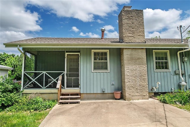 2439 Jasu Dr, Lawrence, KS 66046 - back of house with board and batten siding, covered porch, and a chimney