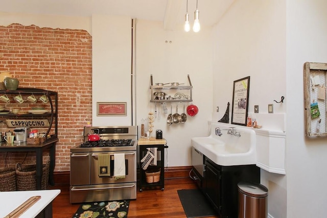 kitchen with hanging light fixtures, brick wall, dark hardwood / wood-style floors, double oven range, and sink