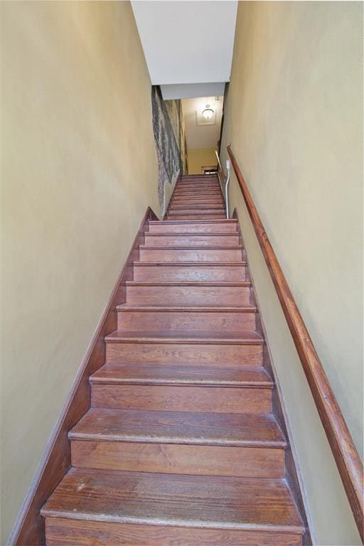 stairway featuring a towering ceiling