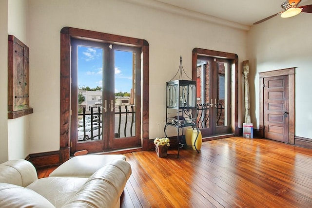 interior space with crown molding, ceiling fan, french doors, and hardwood / wood-style floors