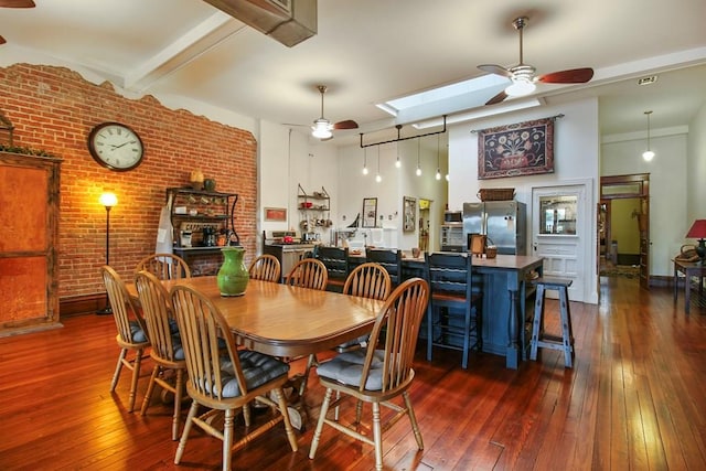 dining room with dark wood-type flooring, ceiling fan, and a skylight