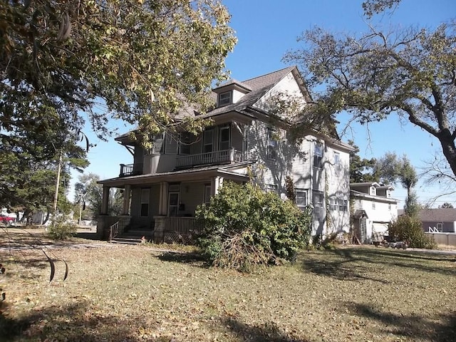 exterior space with covered porch and a yard