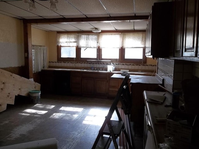 kitchen featuring a paneled ceiling and tile flooring