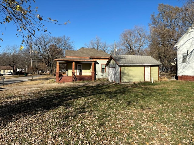 back of property with covered porch and a yard