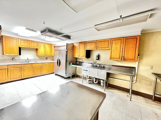 kitchen featuring sink, high end fridge, and light tile floors