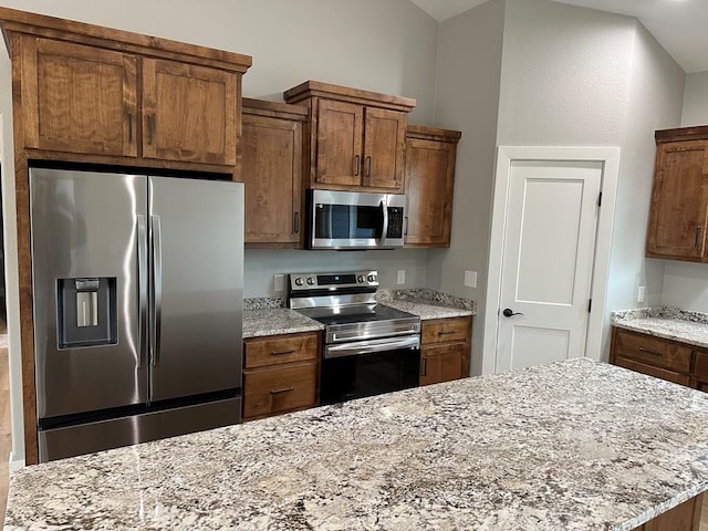 kitchen featuring light stone counters and stainless steel appliances