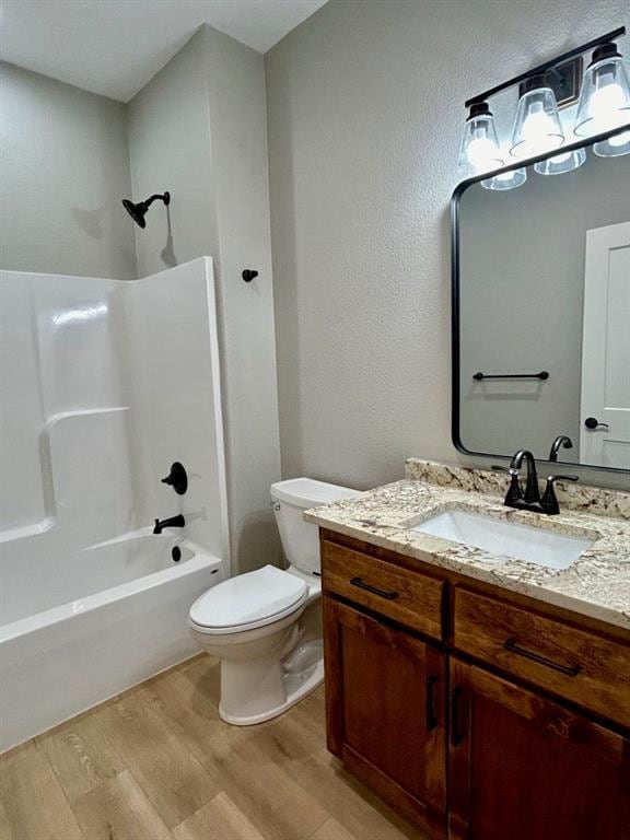 full bathroom with vanity, hardwood / wood-style flooring, toilet, and tub / shower combination