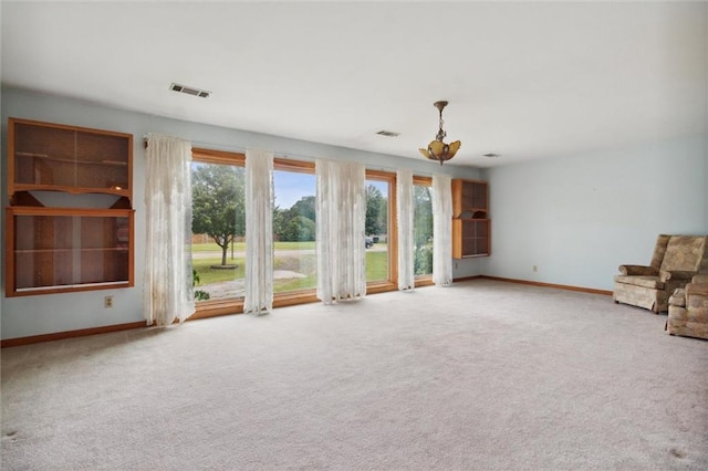 unfurnished living room with plenty of natural light and carpet flooring