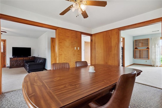 carpeted dining area with ceiling fan