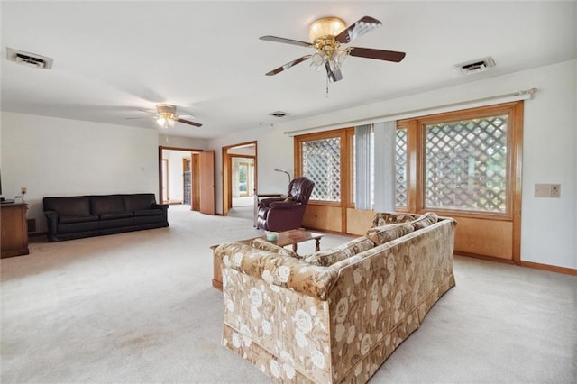 carpeted living room with ceiling fan