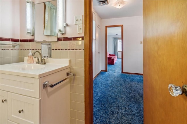 bathroom featuring vanity and tile walls