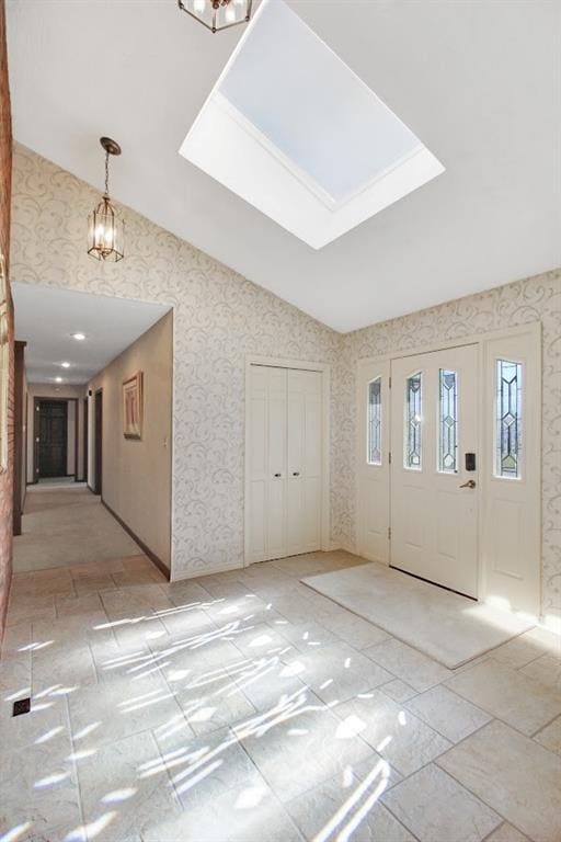 foyer entrance with an inviting chandelier and lofted ceiling