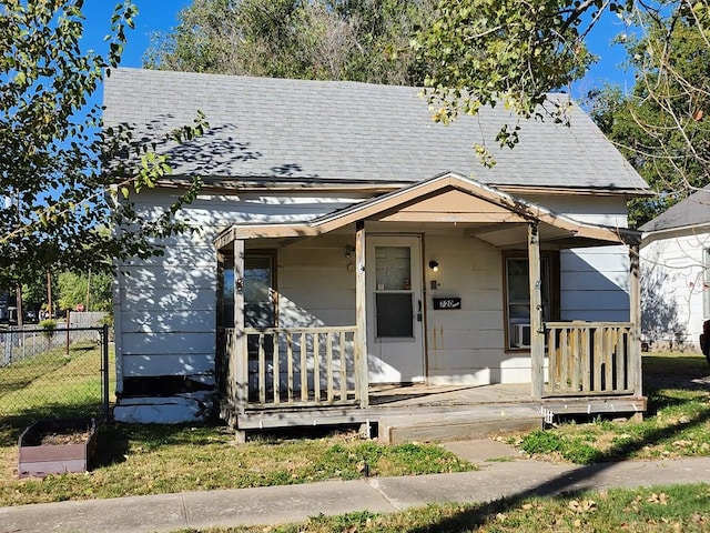 bungalow-style house with covered porch and a front lawn