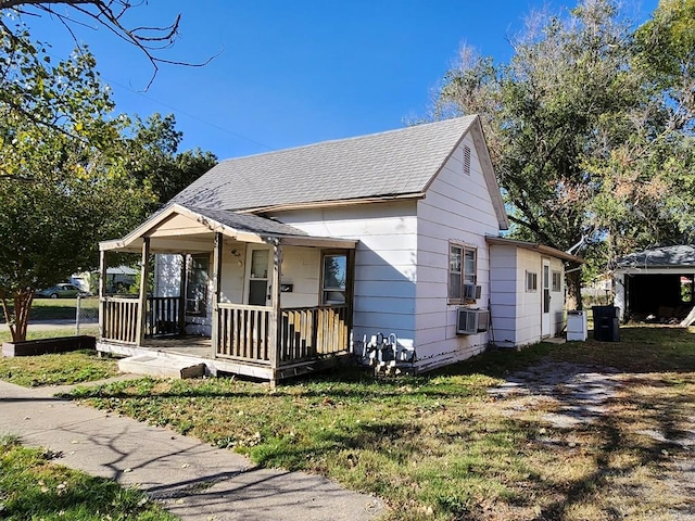 bungalow-style home with a front lawn and covered porch