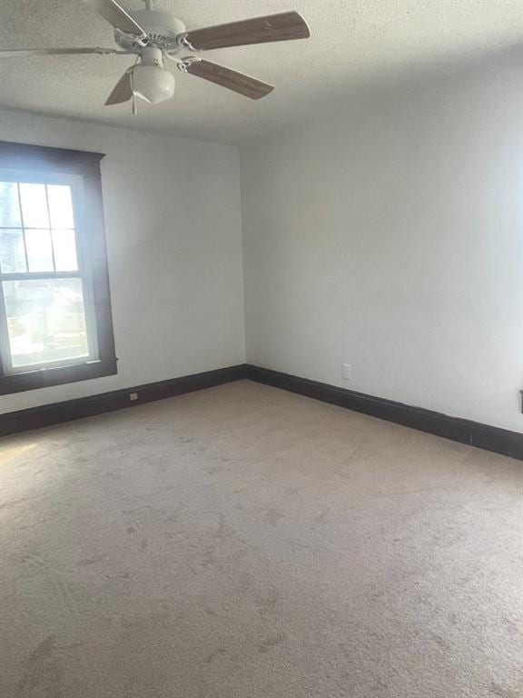 unfurnished room with ceiling fan, carpet floors, and a textured ceiling